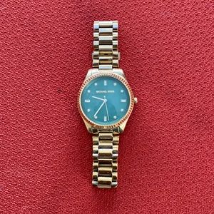 Women’s gold Michael Kors watch.